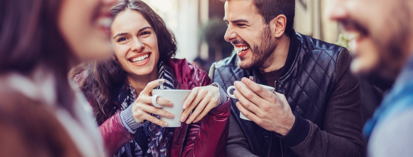 Happy young people having drinks outdoors