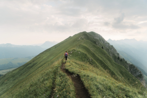 Woman climbing on the mountain ridge in Alps