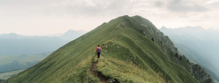Woman climbing on the mountain ridge in Alps